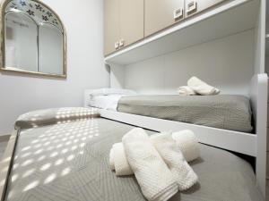 two beds in a room with white walls and a mirror at Unit 120 in SantʼAgata di Militello