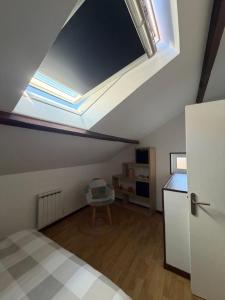 a bedroom with a ceiling with a skylight at L'Envol in Tillé