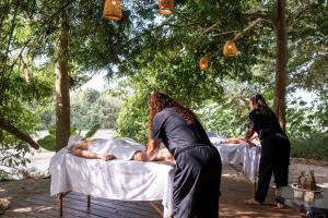 a couple of people laying on beds under trees at Nómada Tayrona - Riverside Suites in Los Naranjos +21 photos