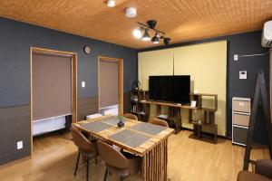 a dining room with a table and a television at Chillax Hida Takayama in Takayama