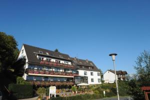 a large white building with flowers in front of it at BELVEDERE - das BIO HOTEL Garni & SuiteHotel am Edersee ! Unser Geschenk für Sie, auch die GästeCard GrimmHeimat! in Waldeck