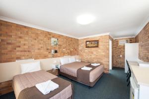 A bed or beds in a room at Buckaroo Motor Inn