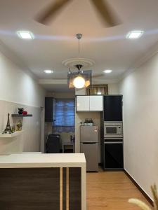 a kitchen with black and white appliances in a room at Suzys homestay in Kuantan