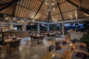 a restaurant with tables and chairs in a room at Villa Mirah Ubud in Ubud
