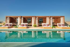 a swimming pool with lounge chairs next to a house at Virgin Hotels Dallas in Dallas