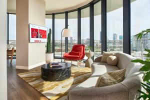 a living room with a couch and a red chair at Virgin Hotels Dallas in Dallas