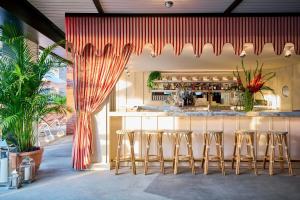 a bar with stools in a room with a counter at Virgin Hotels New Orleans in New Orleans