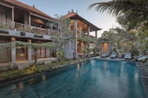 a swimming pool in front of a house at Villa Mirah Ubud in Ubud