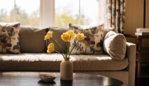 a vase with yellow flowers on a table in a living room at Mountain View Grand Resort & Spa in Whitefield