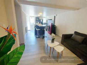 a living room with a couch and a table at Appartement Bois de doubs in Pontarlier