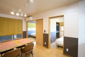 a dining room with a table and a bedroom at Chillax Hida Takayama in Takayama