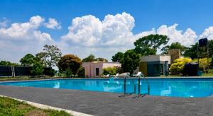 a swimming pool with blue water and clouds in the sky at The Gray Haven Lakeside Condo in Entebbe in Entebbe