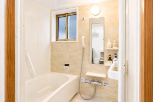 a bathroom with a tub and a sink and a mirror at Chillax Hida Takayama in Takayama +45 photos