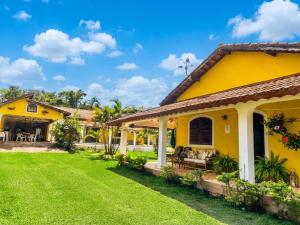 a yellow house with a yard at Pousada casa amarela Analândia SP in Analândia