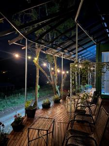 a deck at night with chairs and a table at Pousada Jardim Encantado - Suítes em Container na cidade do Cristo Protetor - Encantado RS in Encantado