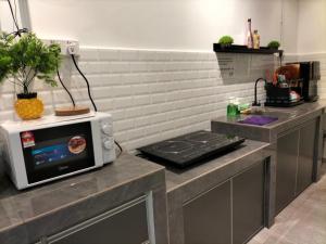 a kitchen with a microwave and a stove at 910 Entire Homestay Seremban Town, Templer, Lobak, Lekas Highway in Seremban +15 photos