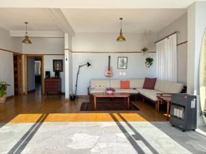 a living room with a couch and a tv at Beach Paradise in Muizenberg
