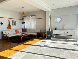 a living room with a couch and a piano at Beach Paradise in Muizenberg +23 photos