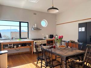 a kitchen with a table and chairs in a kitchen at Beach Paradise in Muizenberg
