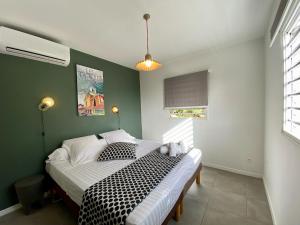 a bedroom with a bed with black and white sheets at Villa APOLLINAIRE in Les Trois-Îlets +35 photos