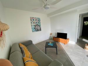 a living room with a couch and a table at Villa APOLLINAIRE in Les Trois-Îlets
