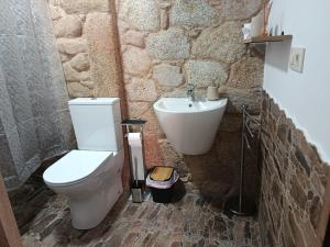 a bathroom with a white toilet and a sink at A casa do sal 