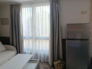 a living room with a large window with curtains at A casa do sal 