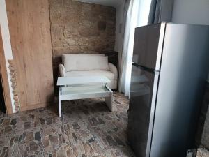 a living room with a couch and a refrigerator at A casa do sal 