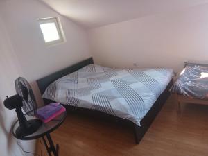 a bedroom with a bed and a table and a chair at Tiha noc apartmani in Belgrade +3 photos