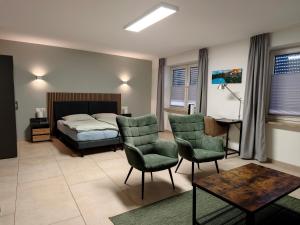 a bedroom with a bed and two chairs and a table at Gästehaus Ferienwohnung Zimmer 2B Jülich in Jülich