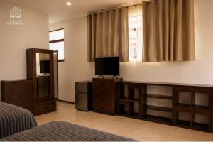 a bedroom with a bed and a television and a window at Habitación Privada in Jacuaro