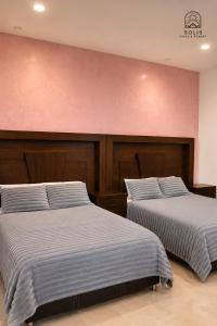 two beds sitting next to each other in a room at Habitación Privada in Jacuaro
