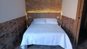 a bed in a room with a brick wall at A casa do sal 