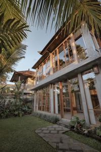 a house with a palm tree in front of it at Villa Mirah Ubud in Ubud