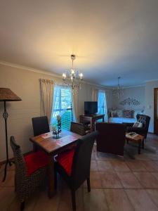 a living room with a table and chairs and a couch at De Kleine Herberg in Durbanville