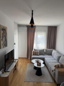 a living room with a couch and a tv at Lovely apartmant Bar in Bar