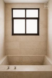a bath tub with two faucets and a window at Habitación Privada in Jacuaro +4 photos