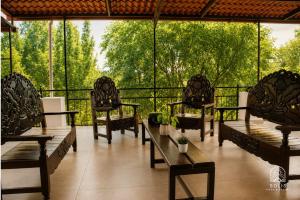 a group of chairs and tables on a balcony at Habitación Privada in Jacuaro