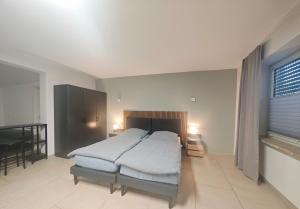 a bedroom with a bed and a table and a window at Gästehaus Ferienwohnung Zimmer 2B Jülich in Jülich