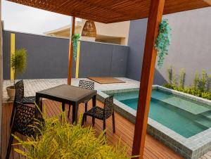 a patio with a table and chairs next to a swimming pool at Casa com vista para o mar e piscina em Milagres in São Miguel dos Milagres +23 photos