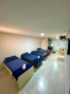 a room with three beds in it with a kitchen at Studio 107 in São Paulo