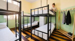 a woman standing in a room with bunk beds at Odara Hostel & Guesthouse in Salvador