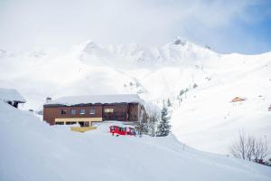 a building in the snow next to a mountain at The Télécabine in Les Crosets