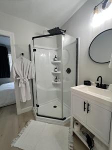 a white bathroom with a shower and a sink at The Hideaway on Tacketts - Shipping Container in Hurricane +31 photos
