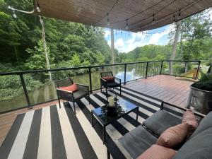 a screened in porch with a couch and chairs on a deck at The Hideaway on Tacketts - Shipping Container in Hurricane