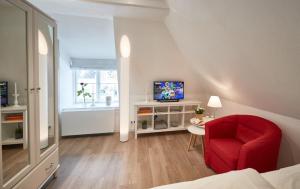 a living room with a red chair and a television at Zur Schleikate in Boren