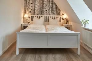 a bedroom with a white bed in a attic at Zur Schleikate in Boren
