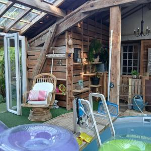 a backyard patio with a hot tub and a house at Gîte l'Atelier Bois in Gaillères
