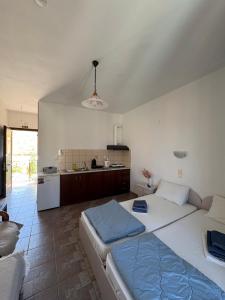 a bedroom with a large bed and a kitchen at Vista del Mare Rooms 1 in Agios Ioannis Kaspaka