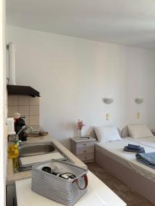 a kitchen with a sink and a bed in a room at Vista del Mare Rooms 1 in Agios Ioannis Kaspaka